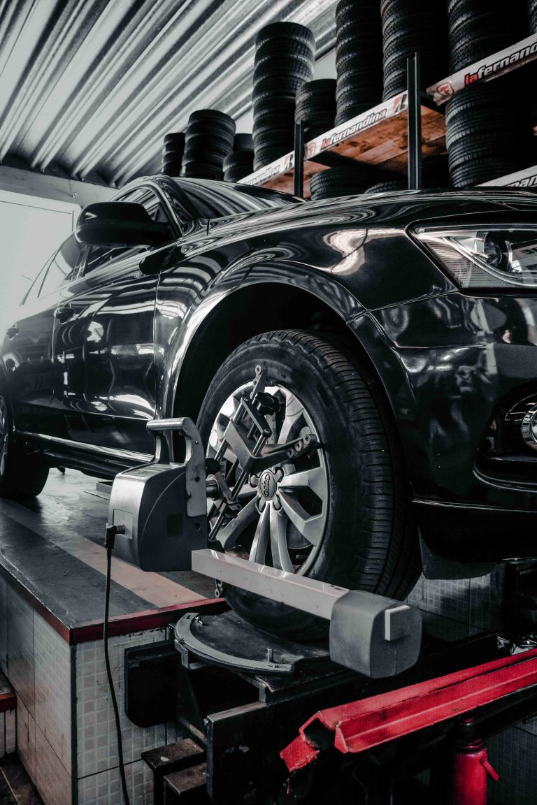 Auto elevado en el equipo de alineación del taller