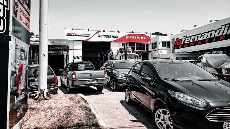 Frente de La Fernandina Neumáticos en Maldonado con autos estacionados